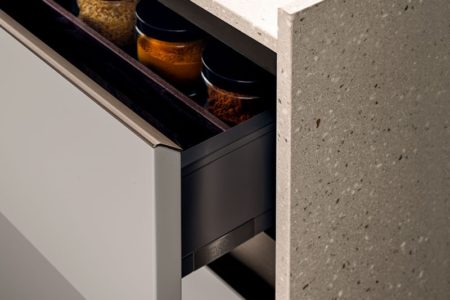 Cassetto aperto della cucina italiana di design senza maniglie E0, che mostra dei barattoli di spezie.