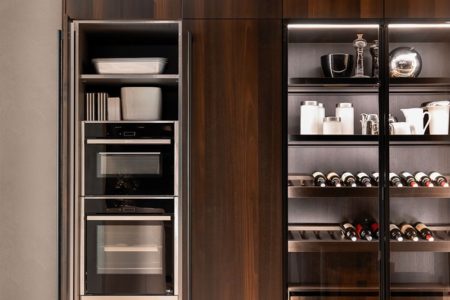 Dettaglio del forno e della vetrina della cucina da sogno moderna senza maniglie E0, con ante in legno scuro di design.