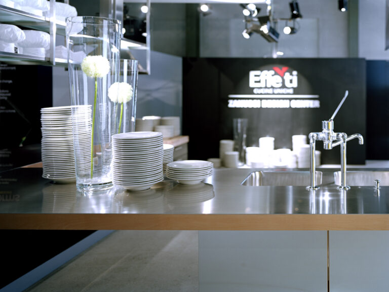 cucina effetti in uno showroom realizzata in alluminio su cui sono riposti dei piatti