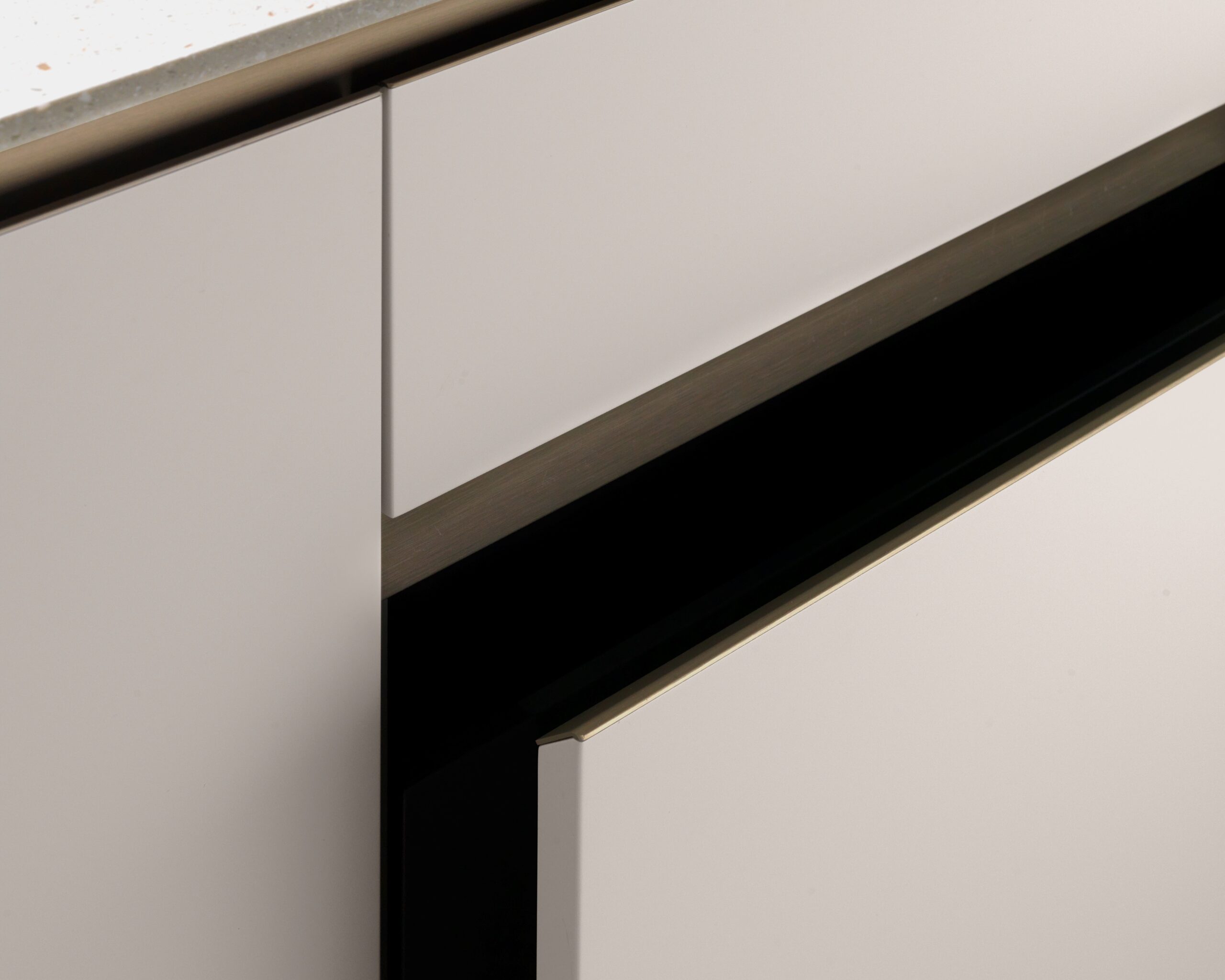 Parte della cucina moderna E0 senza maniglie, con ante bianche e dettagli in acciaio inox, dal design minimalista.