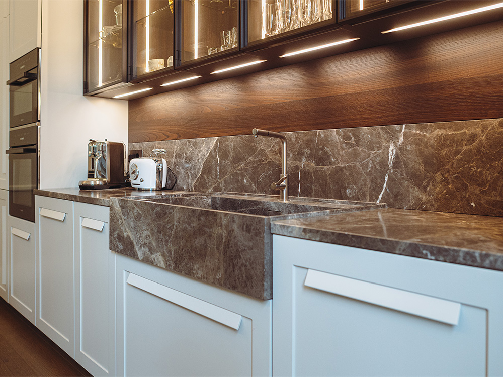 Cucina moderna italiana in legno bianca, con maniglie ergonomiche.